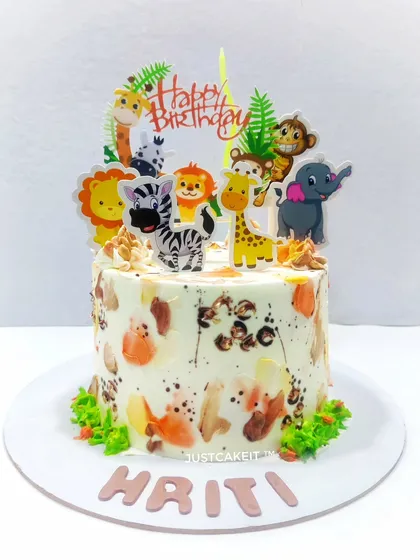 This simple animal theme cake features a unique hand-painted texture on the whipped cream. The cute animal toppers make it a fun and artistic centerpiece for a child's birthday.