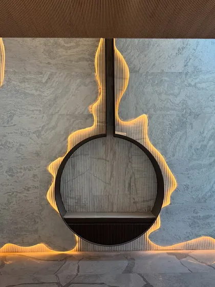 This custom-designed fireplace feature is an example of our commitment to bespoke details. We worked with backlit, textured stone to create a sculptural element that is both a source of warmth and a piece of art, showcasing how we integrate light and material.