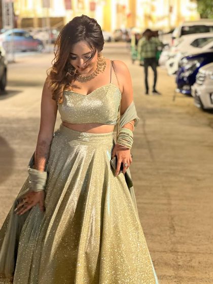 A candid shot looking down at the glittering lehenga. This shows a genuine appreciation for the outfit's beauty.