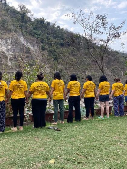United in our journey. Students hold hands, looking out at the serene landscape of Rishikesh, symbolizing our shared path of growth.