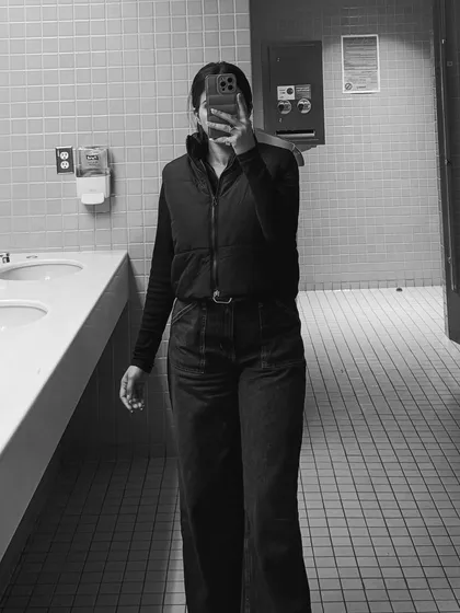 A black and white mirror selfie, adding an artistic touch to this casual college outfit featuring a vest and wide-leg pants.