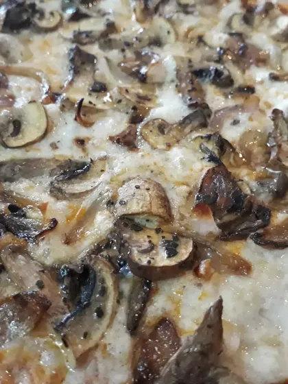 A close-up shot of the mushroom and caramelized onion pizza, showing the melted texture of the in-house vegan cheese. It's hard to believe this is both vegan and gluten-free.