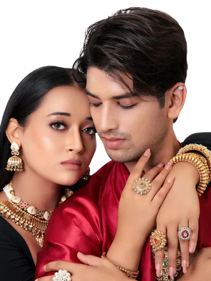 An intimate and regal pose. This close-up focuses on the models' expressions and the beautiful rings and necklaces, perfect for a jewelry lookbook.