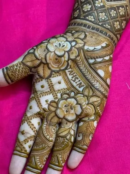 A personalized design with the name "TAHSIN" beautifully integrated into a floral pattern on the palm.