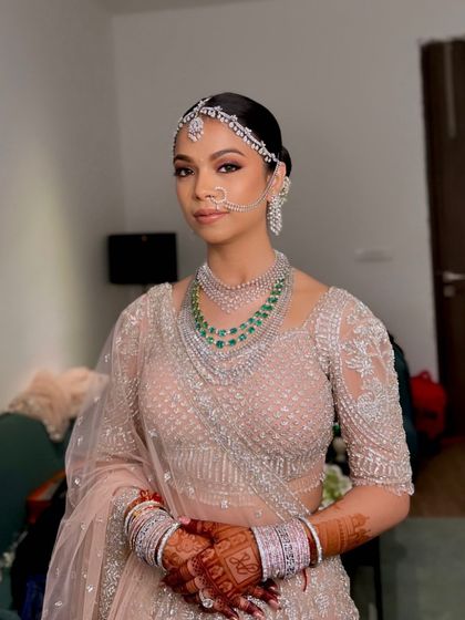 A final look at Hemangini's stunning pastel bridal attire. The makeup features a clean base, defined eyes, and a neutral lip.