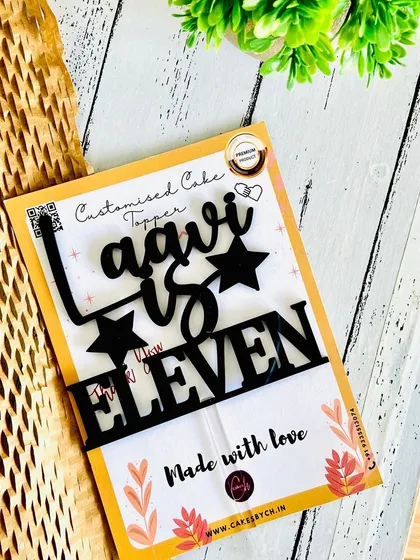 The "Laavi is Eleven" topper in black acrylic, shown with its protective packaging, highlighting the care taken with each order.