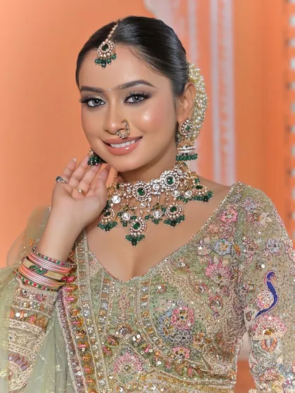 A bright, happy portrait of the same bride. Her smile shows her confidence, and the jewellery, including the nath and jhumkas, completes her radiant look.