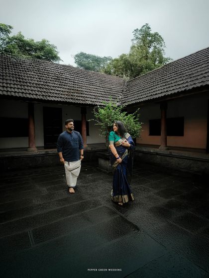 A moment of connection in the open courtyard of a traditional Kerala home. The natural, moody lighting adds a layer of romance to this pre-wedding photograph.