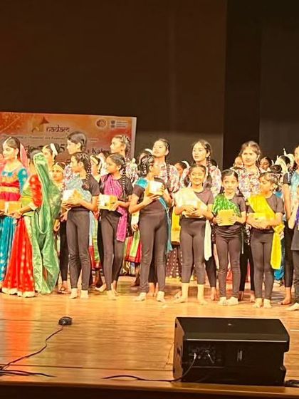 The entire group of junior performers on stage receiving appreciation. It's a rewarding experience for them and for us as teachers.