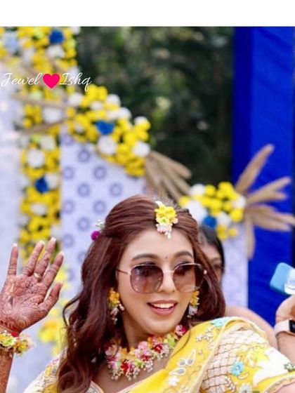 A close-up of the bride dancing, showing off her custom floral earrings and maang tikka.