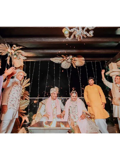 The couple sits by the sacred fire during their Pheras, surrounded by the blessings of their family. This shot captures the traditional essence and communal spirit of a Hindu wedding.