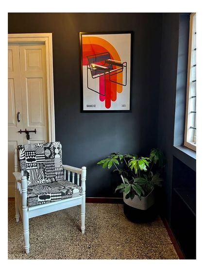 A seating corner in the co-living apartment, where contemporary art and patterned upholstery contrast with the dark walls. This space is designed to be a comfortable and stylish social spot for residents.