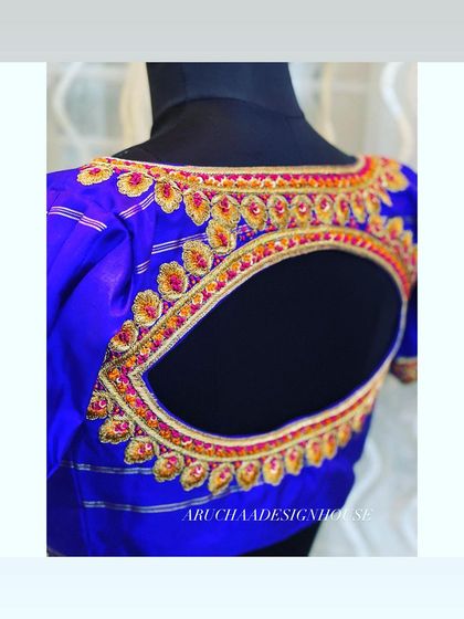 Another angle of the radiant blue blouse, showing the texture and shine of the silk fabric and the detailed handwork around the cutout.