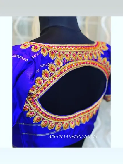 Another angle of the radiant blue blouse, showing the texture and shine of the silk fabric and the detailed handwork around the cutout.