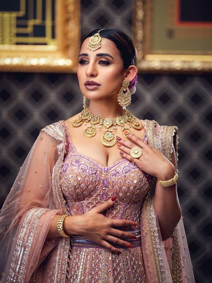 A portrait of a bride in a pastel lehenga, captured with soft lighting to emphasize the delicate color palette and intricate beadwork. The focus is on creating a dreamy and romantic mood.