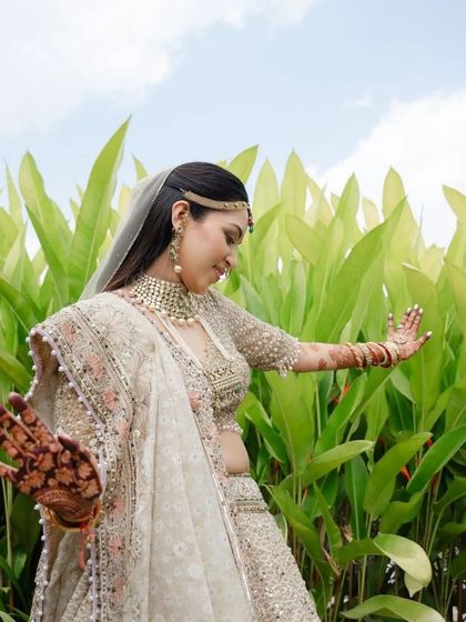 A joyful bride showing off her wedding look, with her beautifully stained henna adding to her radiance.