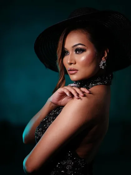 Another artistic shot of the bold, smoky eye look. The wide-brimmed hat adds a touch of mystery and high-fashion drama.