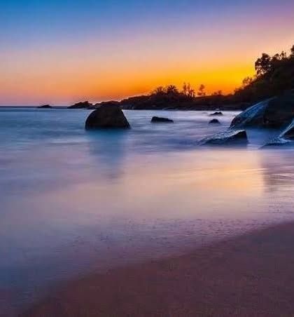 A beautiful, calm sunset over the sea at Gokarna, with the water reflecting the colors of the sky.