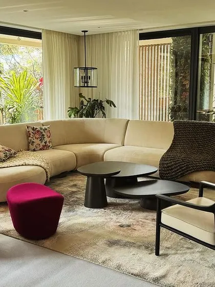 We designed this living space around a custom curved sofa that encourages conversation, complemented by a sculptural magenta lounge chair. The furniture works together to create a room that is open, connected to the outdoors, and full of personality.