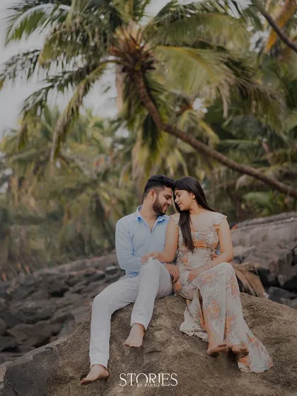 A quiet moment on a rocky shore, with palm trees framing the scene. This shot captures the peaceful, romantic essence of a beach pre-wedding shoot, away from the crowds.
