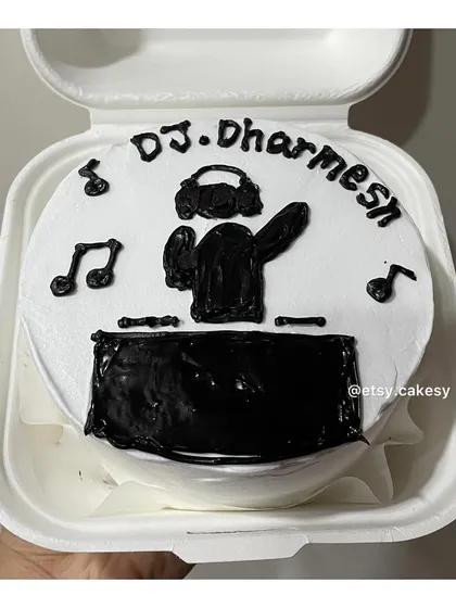 A custom bento cake for a music lover, 'DJ Dharmesh', complete with headphones, a turntable, and musical notes.