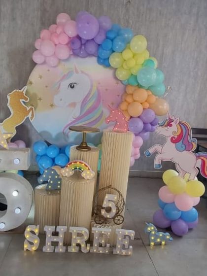 A side view of the unicorn party setup, showing the layered unicorn cutouts.
