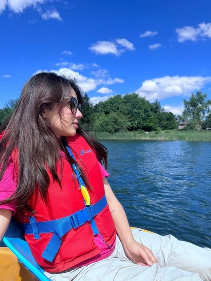 A candid shot while boating, wearing a life vest over a casual outfit.