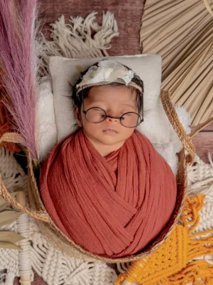 A boho-chic dreamer. With dried palms, macrame, and a pair of stylish little glasses, I can create a trendy, rustic vibe for your baby's photoshoot.