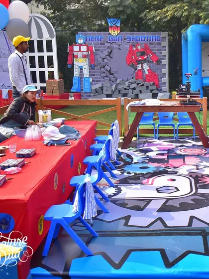 A view of the craft and activity area for the Transformers party. The themed flooring and backdrop for the Nerf gun shooting and archery stations show how every detail is considered.