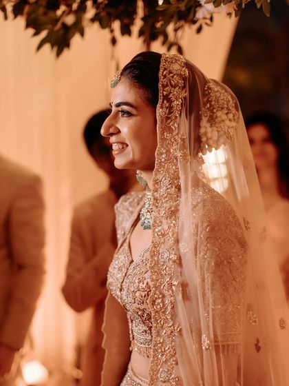 A candid shot through the veil. Her happy smile and glowing makeup are the highlights of this beautiful moment.