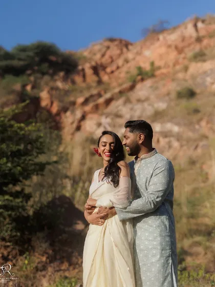 Another angle of their embrace against the rocky hills. This shot captures their loving interaction and the beautiful scenery, creating a timeless engagement portrait.
