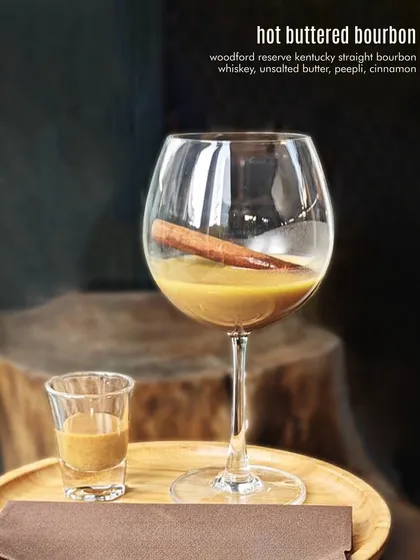 Hot Buttered Bourbon, the ultimate comfort cocktail. Woodford Reserve bourbon is mixed with unsalted butter, peepli, and cinnamon for a warm, rich, and spiced drink.