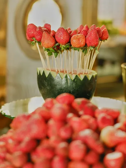 Another view of our creative strawberry displays, this time presented in a carved watermelon bowl. We turn simple fruit into a work of art.