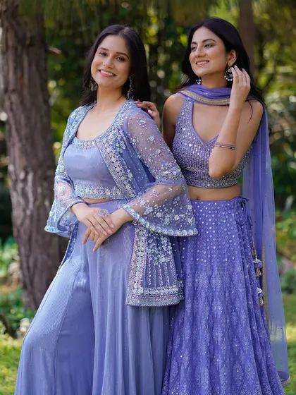 A classic lookbook pose with two models in beautiful lavender ethnic wear. The composition is clean and balanced, allowing customers to see the details of both the lehenga and the coordinated palazzo set.