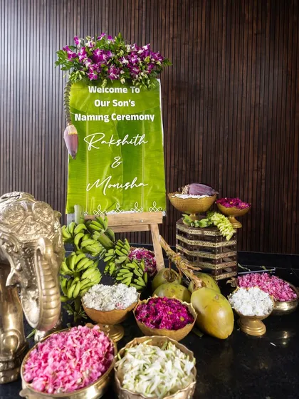 Another view of the elegant welcome station. The reflection on the glossy floor doubles the beauty of the floral arrangement, the custom sign, and the traditional brass elements.