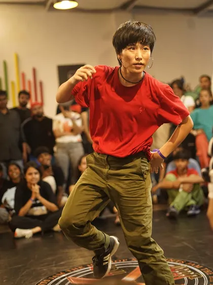 A b-girl competitor focused and ready during her round. The competitive spirit is strong across all categories at our jams.