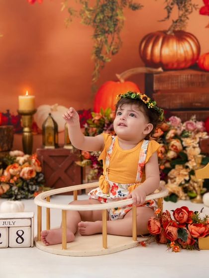 Reaching for the stars, or maybe just the ceiling. This shot captures a sense of wonder and curiosity within the beautiful autumn-themed set.
