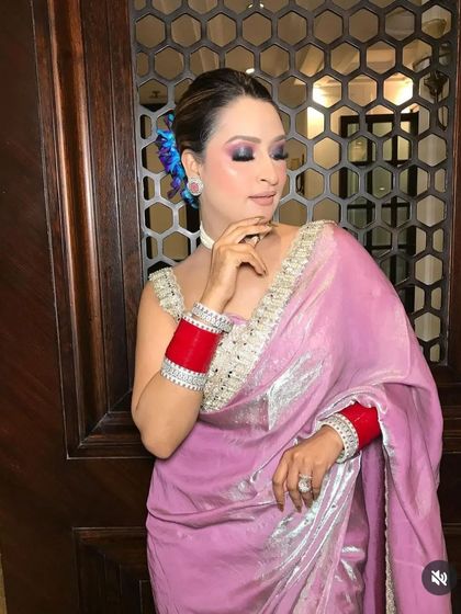 A closer look at the elegant updo, featuring a blue floral accent. This hairstyle is perfect for a wedding guest who wants a sophisticated and polished look.