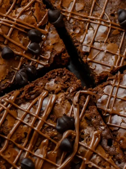 A close-up shot of our brownies, showing the intricate chocolate drizzle and fudgy texture that makes them so irresistible.