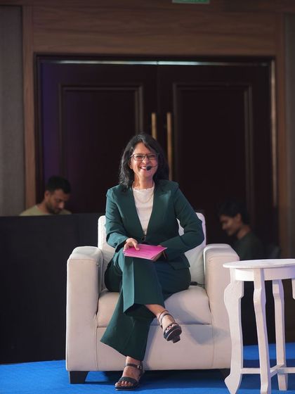 A photo of me sitting in a chair on stage. Words are the building blocks of our reality. Today, choose words that nourish your soul and reflect your awesomeness.