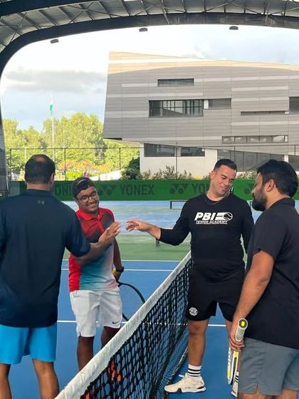 Players enjoying a light-hearted moment at the net. Our adult leagues are as much about community and fun as they are about competition.