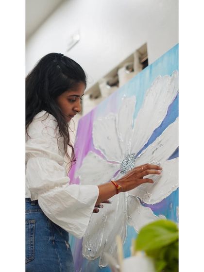 Adding the final touches to a textured floral painting. The contrast between the smooth background and the rough, raised petals is what gives these pieces their unique, tactile quality.