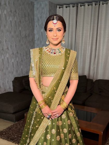 A smiling portrait of the bride, her hair neatly parted and pulled back into an elegant, traditional braid.