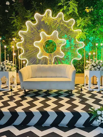 A sober and elegant reception stage with a modern illuminated backdrop, set against a lush green background for a beautiful contrast.