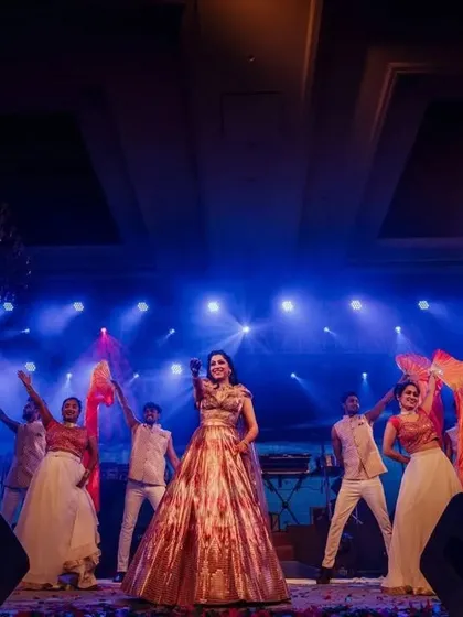 The bride takes center stage for her solo, surrounded by backup dancers with colorful flags. We use props and dancers to elevate a solo performance and give it a grander scale.