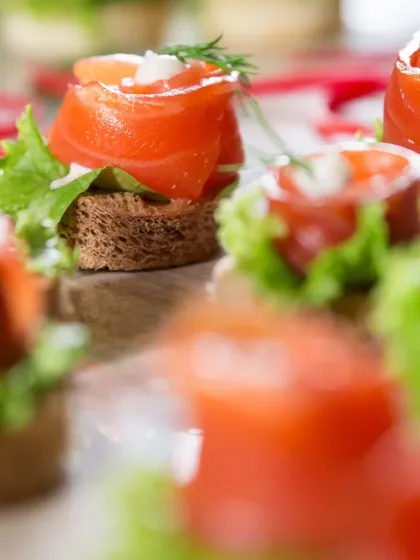 Another view of the Smoked Salmon Canapés, showcasing the beautiful rosette shape of the salmon and the fresh dill garnish. A timeless choice for luxury catering.