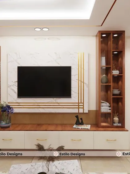 Here is the living room design for the same client, featuring a custom TV unit that incorporates a puja cabinet with traditional jali work. The design balances storage, display, and spiritual elements within a clean, modern framework.
