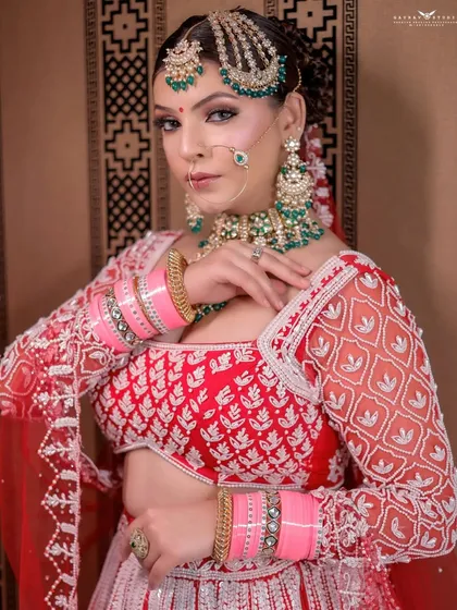 This shot captures the bride's elegant posture, with her hand gently touching her blouse, drawing attention to the details.