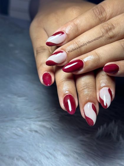 A bold and modern design with a deep burgundy polish and abstract nude swirls.
