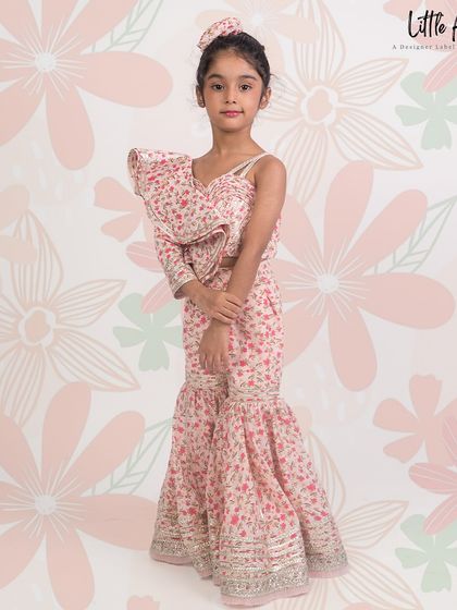 A printed designer garara set with a one shoulder top, combining a floral print with traditional mirror work.